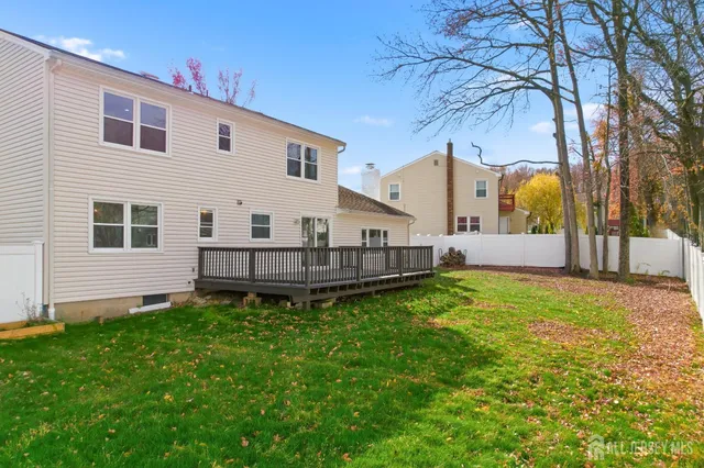 a view of a house with wooden fence and a yard
