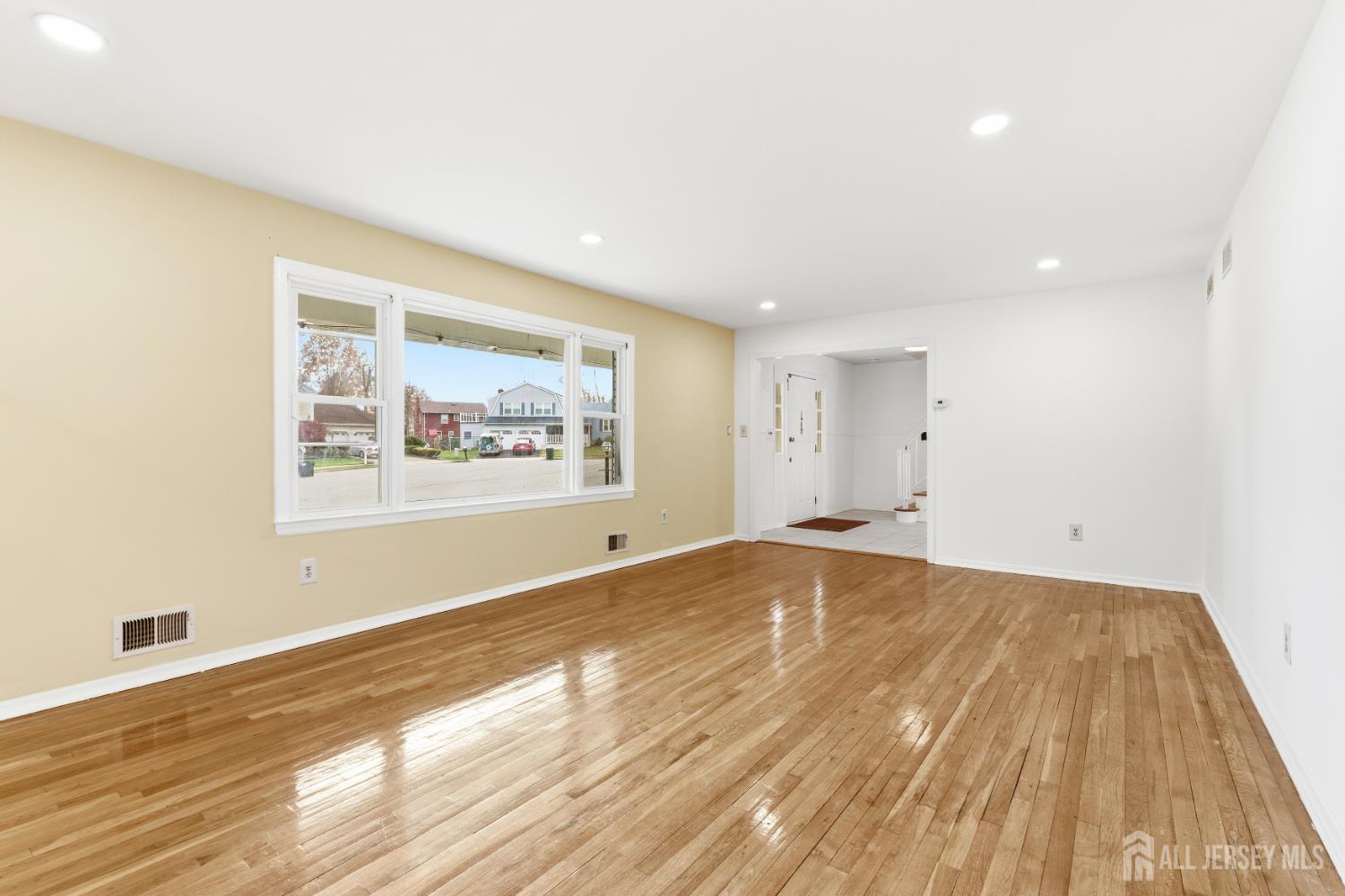 7 Oberlin Court Edison, NJ 08820 - Photo 7 of 40 a view of an empty room with wooden floor and a window