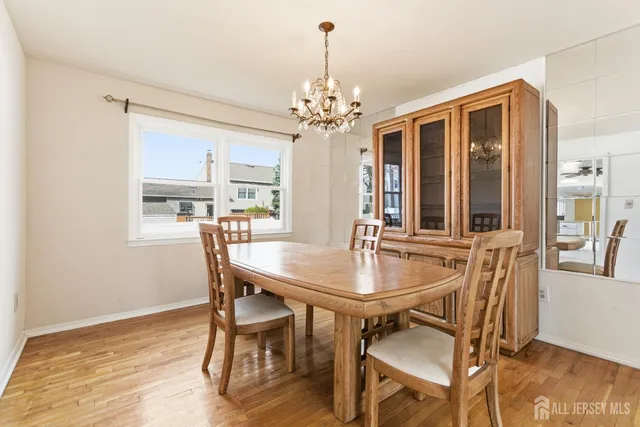 a dining room with furniture a chandelier and wooden floor