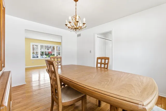 a view of a dining room with furniture a chandelier and wooden floor