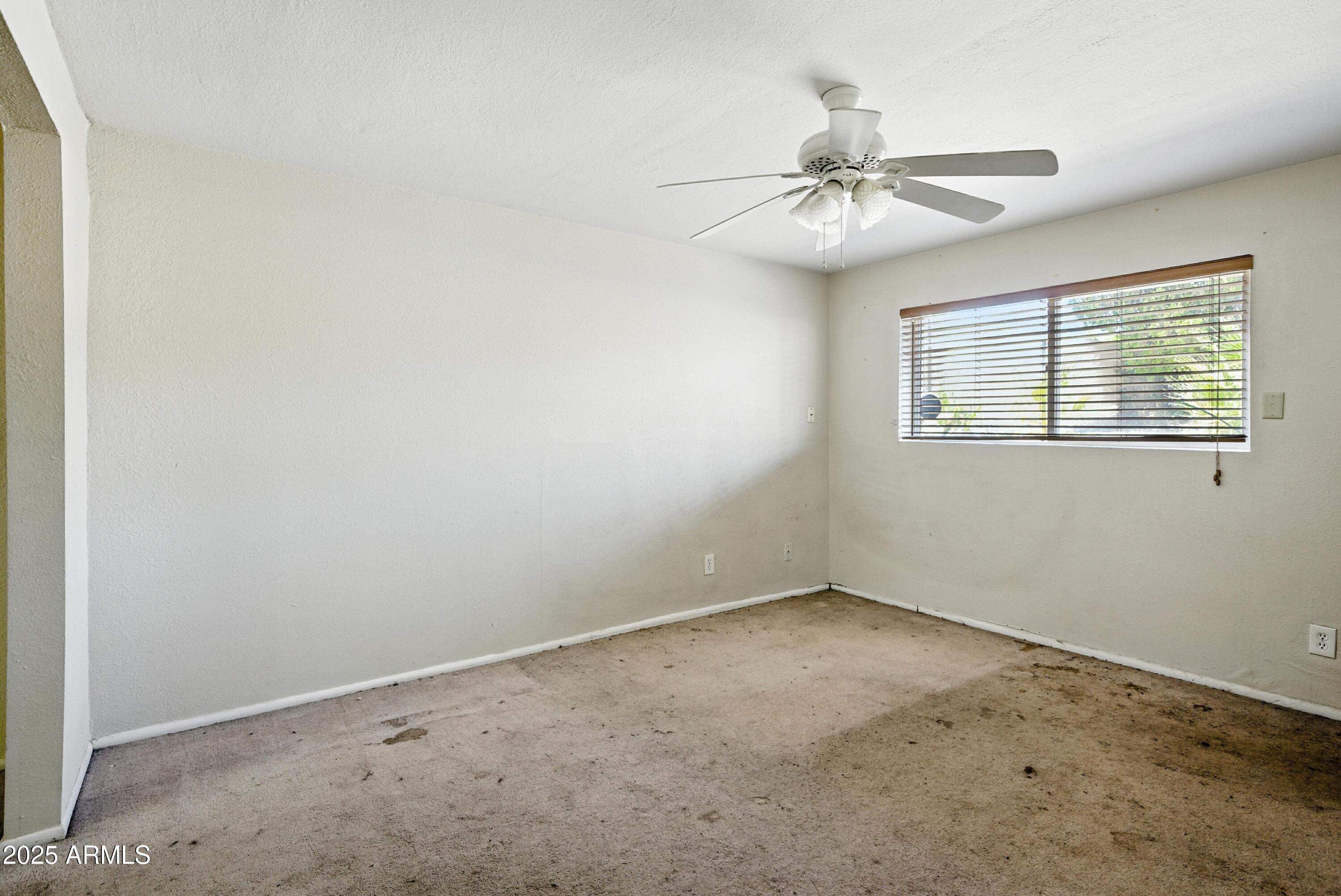 3724 West Bloomfield Road Phoenix, AZ 85029 - Photo 15 of 32 an empty room with a window and a fan