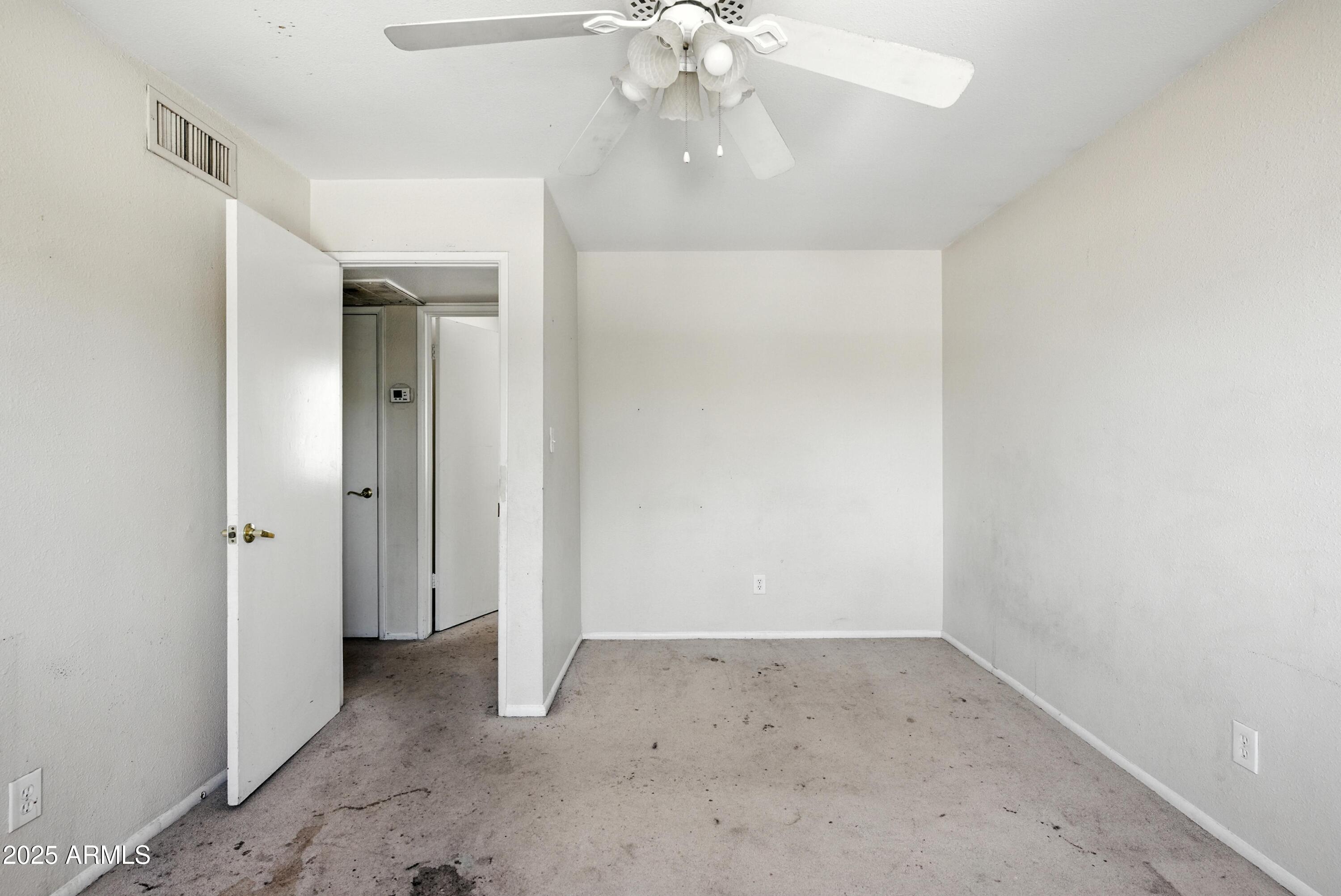 3724 West Bloomfield Road Phoenix, AZ 85029 - Photo 24 of 32 an empty room with a ceiling fan and a bathroom