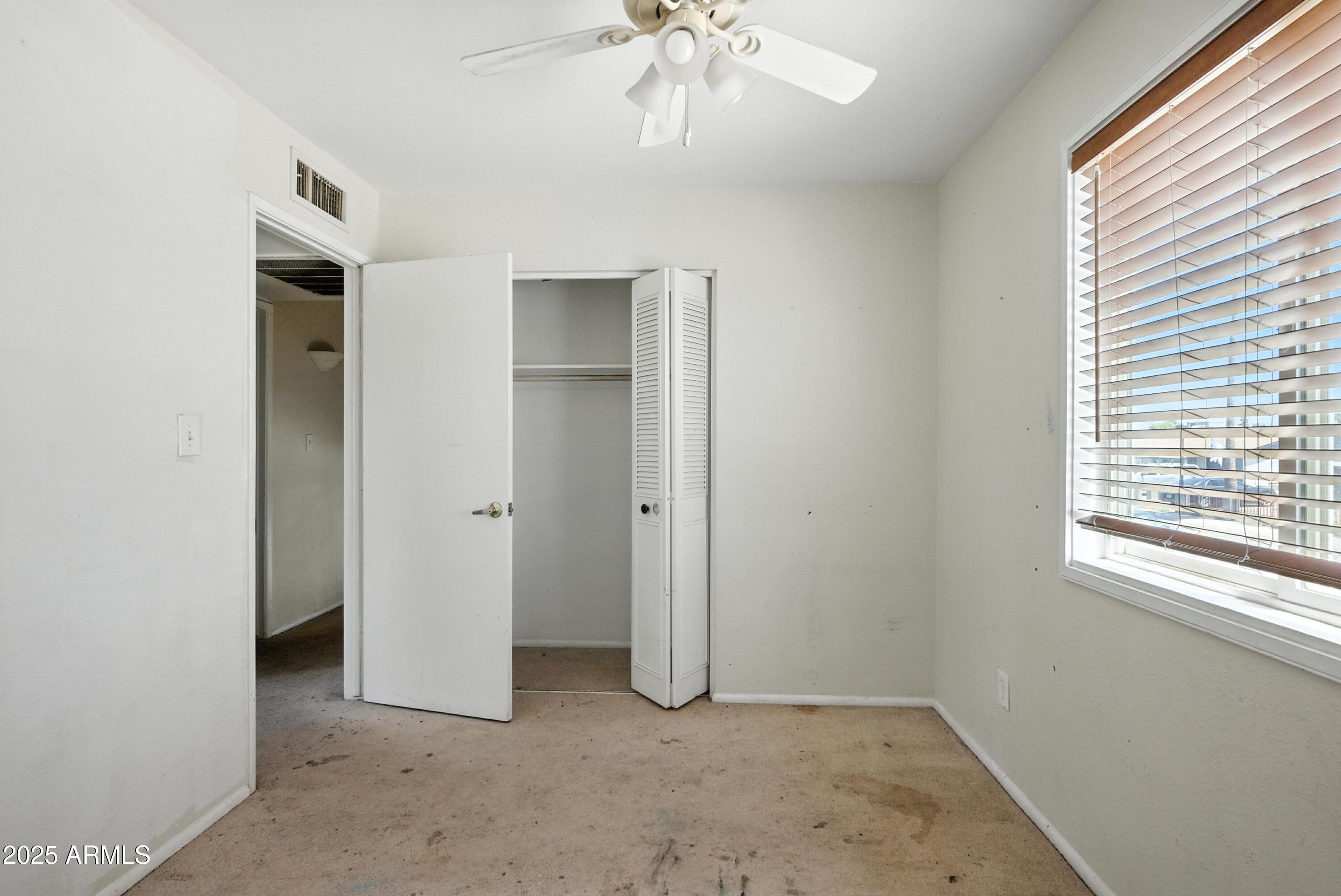 3724 West Bloomfield Road Phoenix, AZ 85029 - Photo 28 of 32 an empty room with a window and a hallway
