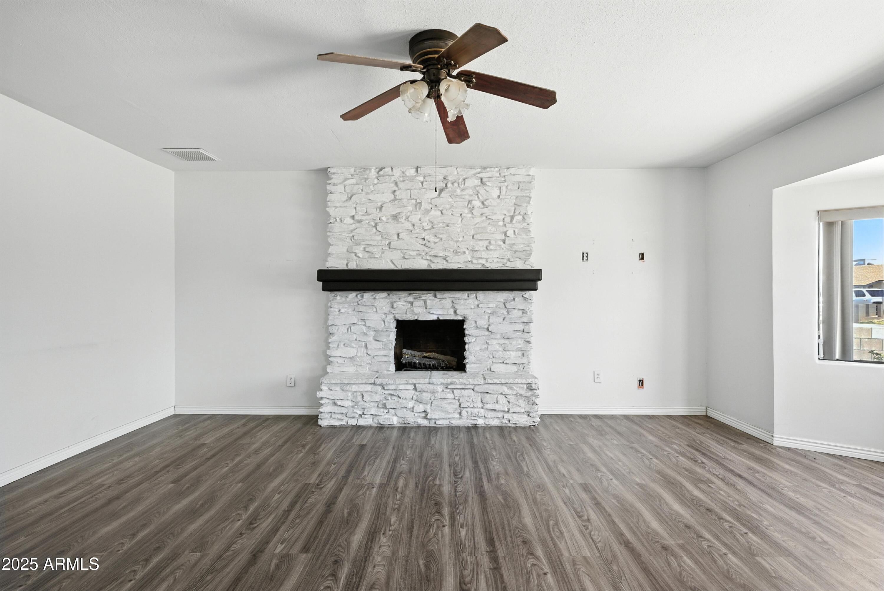 3724 West Bloomfield Road Phoenix, AZ 85029 - Photo 7 of 32 a view of empty room with wooden floor and fireplace