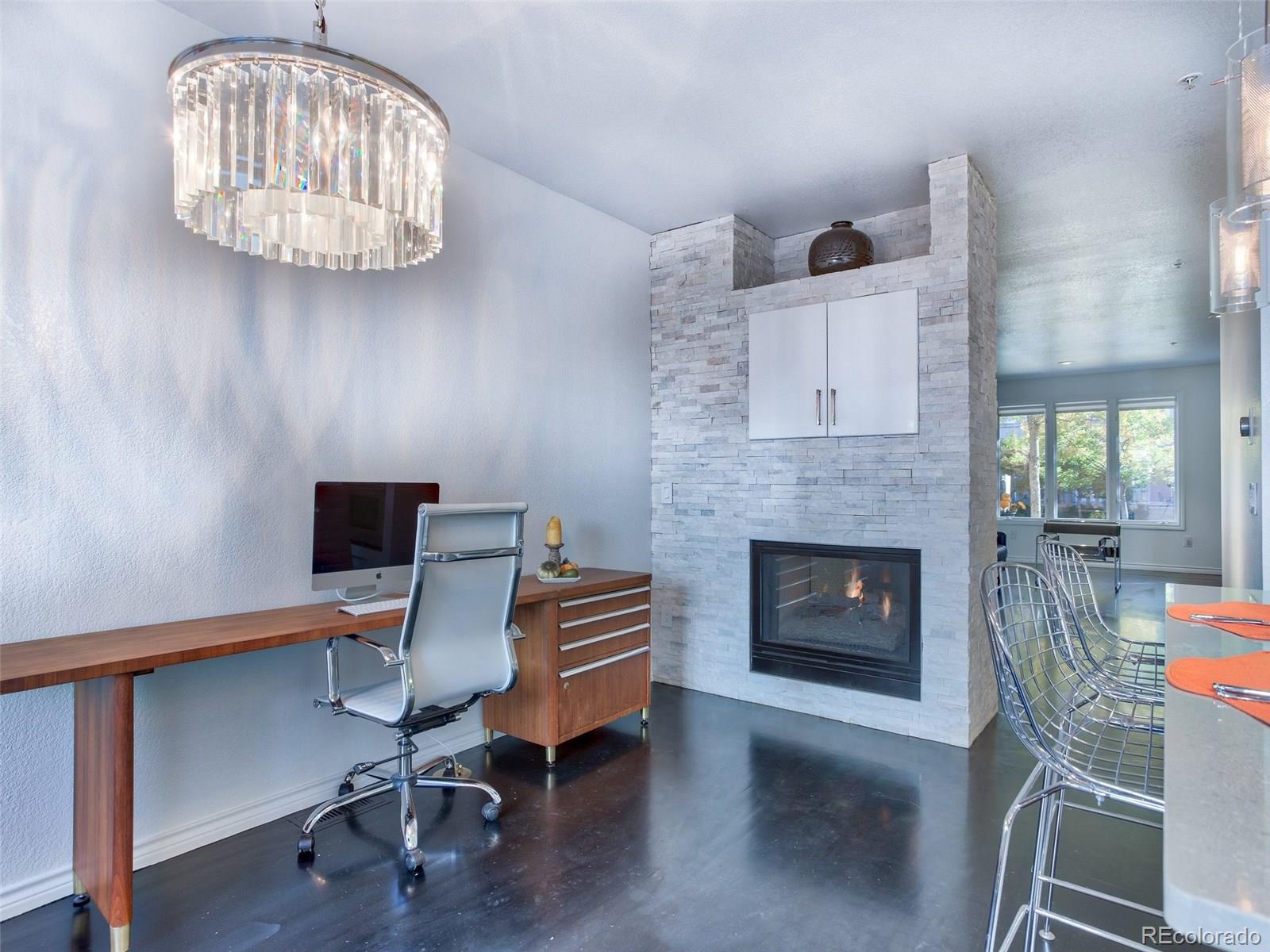 13 South Garfield Street Denver, CO 80209 - Photo 11 of 27 a livingroom with fireplace a dining room and a chandelier