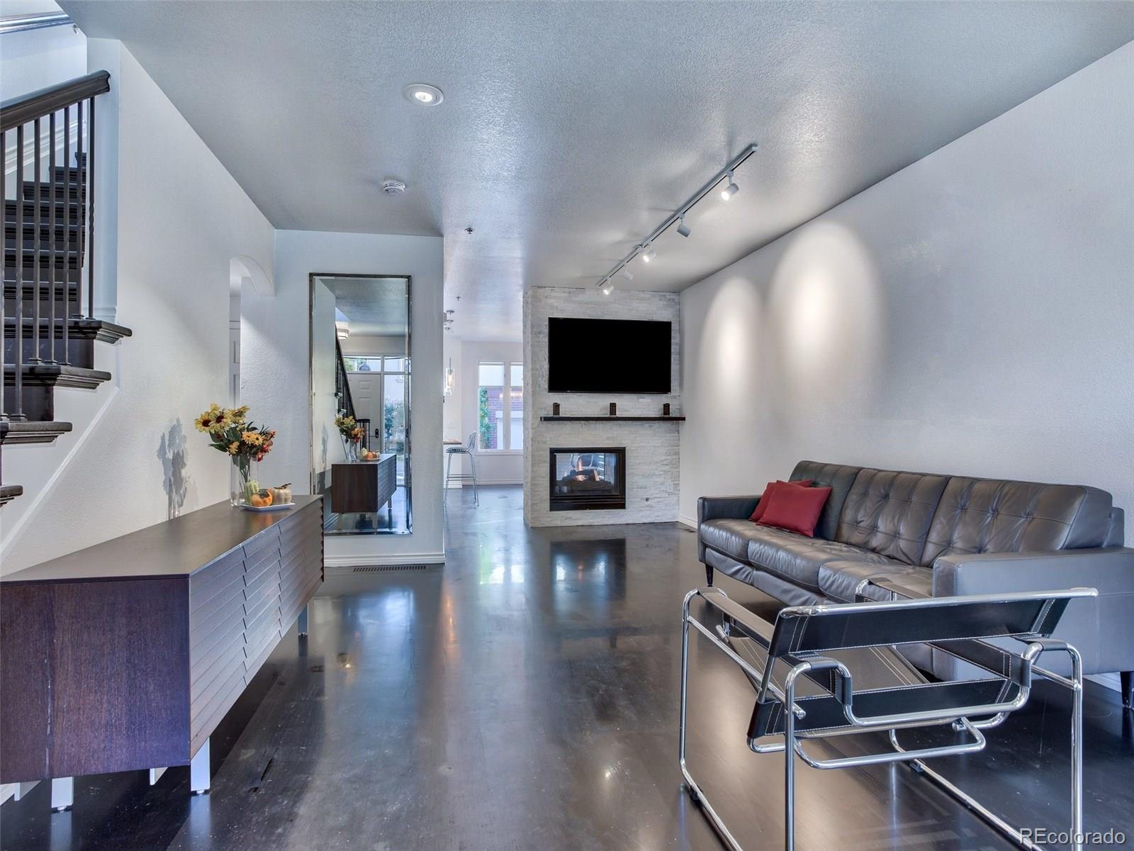13 South Garfield Street Denver, CO 80209 - Photo 3 of 27 a living room with furniture a flat screen tv and a fireplace