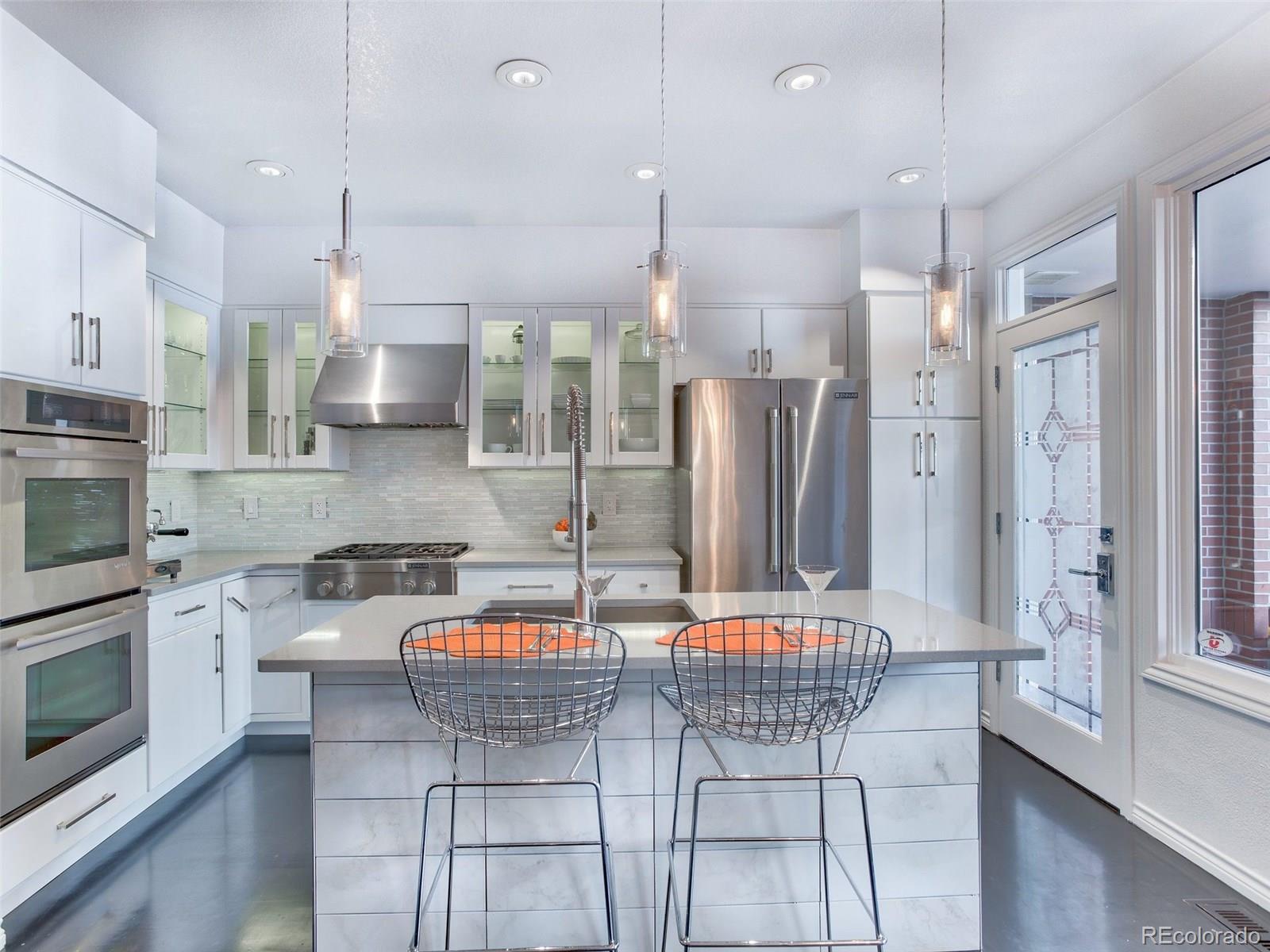 13 South Garfield Street Denver, CO 80209 - Photo 8 of 27 a kitchen with stainless steel appliances granite countertop a refrigerator a stove a sink dishwasher with a dining table and chairs