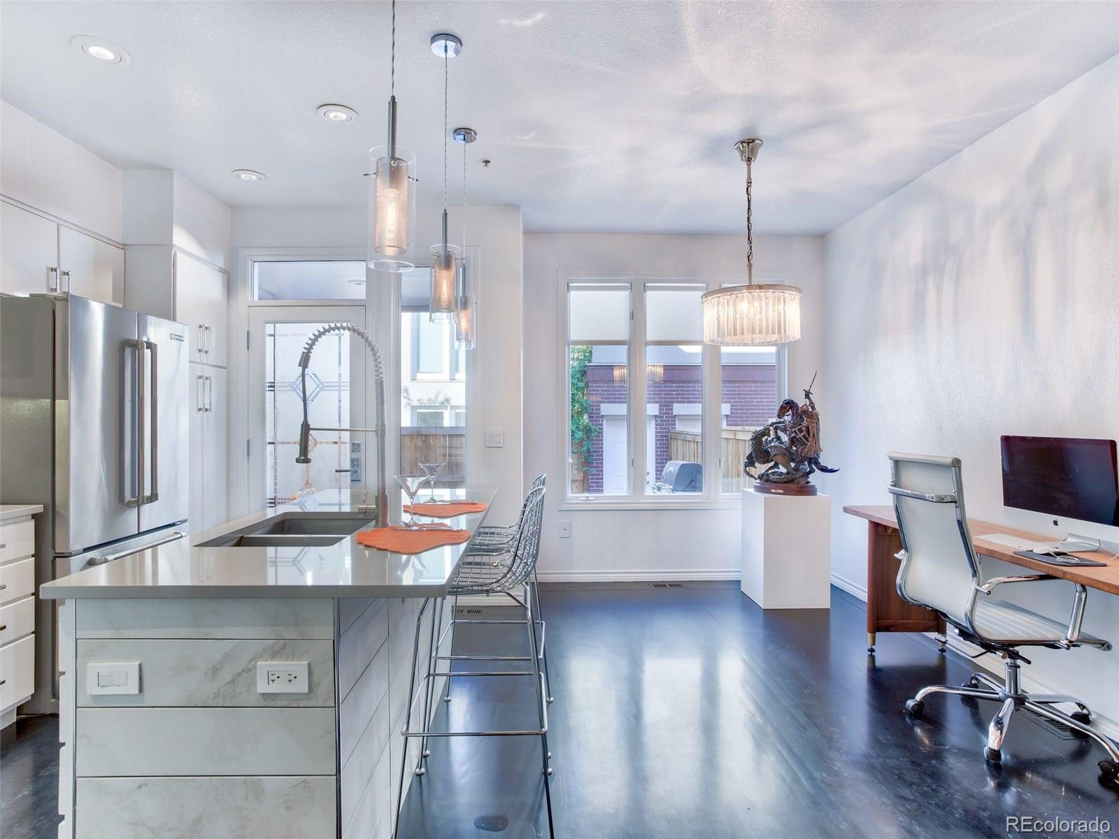 13 South Garfield Street Denver, CO 80209 - Photo 10 of 27 a room with stainless steel appliances kitchen island granite countertop a refrigerator a stove a dining table and chairs with wooden floor