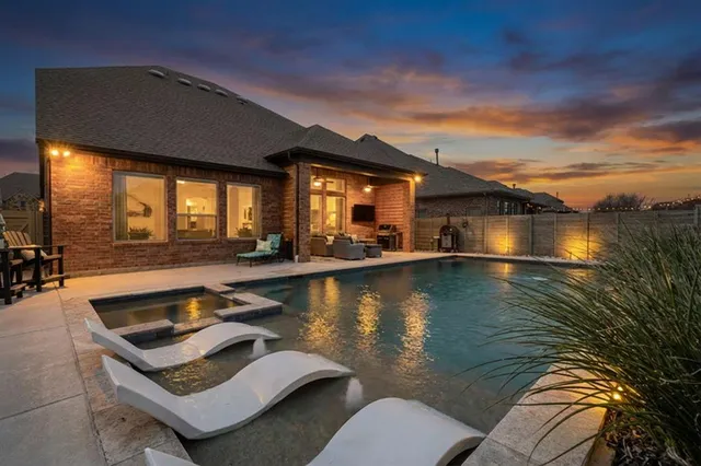 a view of a swimming pool with lounge chairs in patio