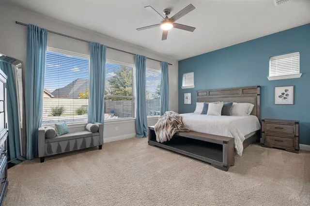 a bed sitting in a spacious bedroom next to a window