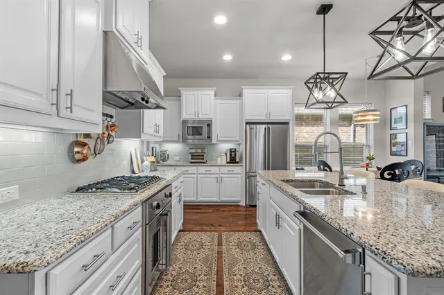 a kitchen with stainless steel appliances granite countertop a sink stove and refrigerator