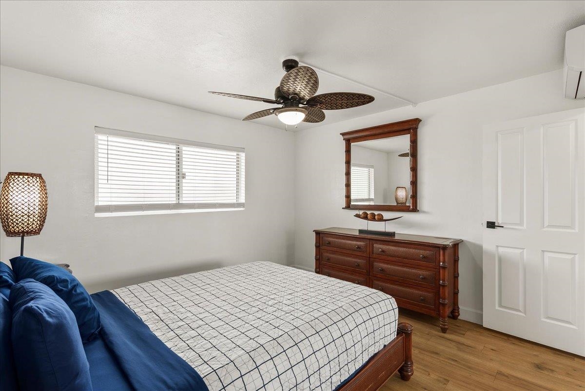 760 South Kihei Road, Unit 405 Kihei, HI 96753 - Photo 27 of 39 a bedroom with a bed and a chandelier