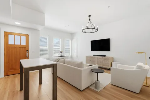 a living room with furniture a flat screen tv and a window
