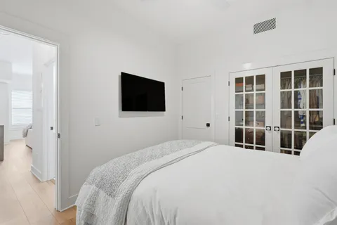 a bedroom with a bed and a flat tv screen in it