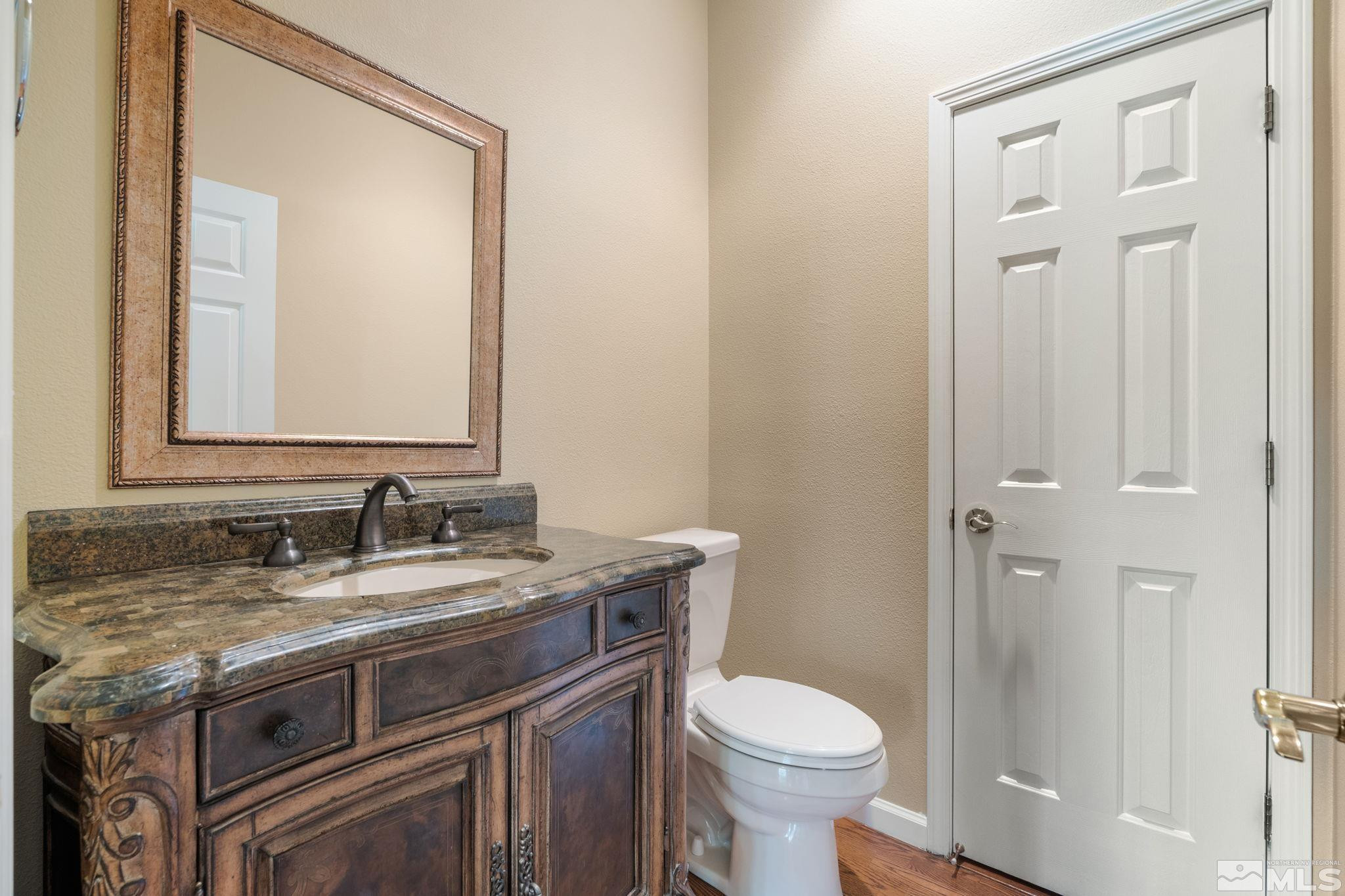 1745 Hunter Creek Road Reno, NV 89519 - Photo 16 of 40 a bathroom with a granite countertop toilet sink and mirror