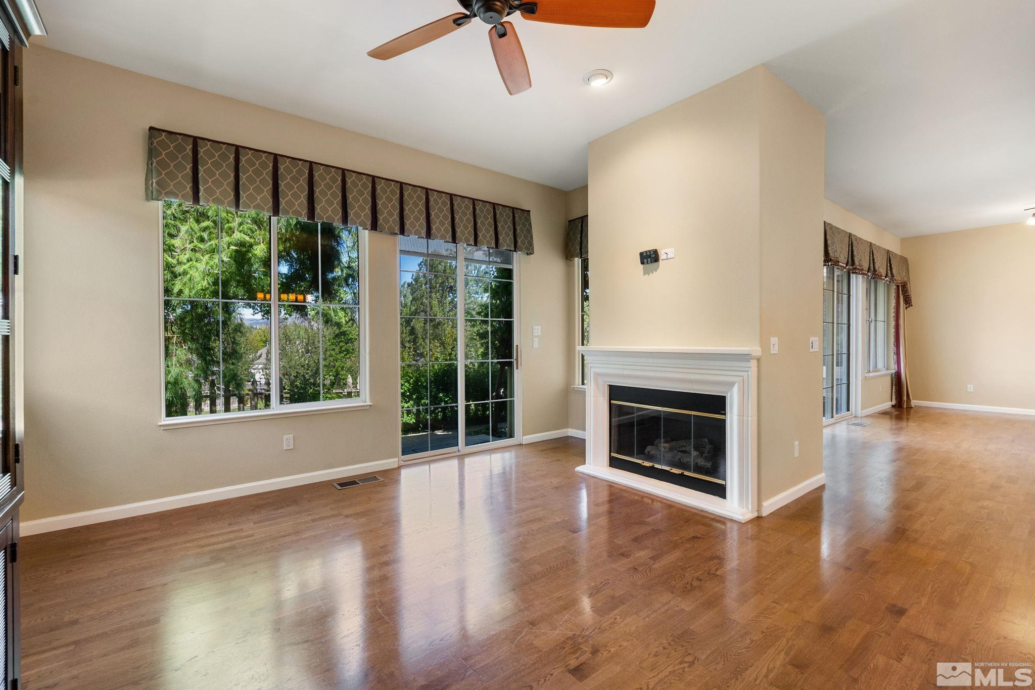 1745 Hunter Creek Road Reno, NV 89519 - Photo 18 of 40 a view of an empty room with wooden floor fireplace and a window