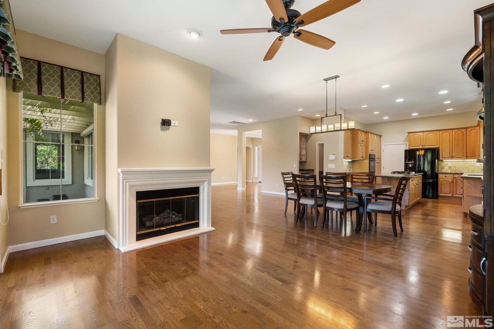 1745 Hunter Creek Road Reno, NV 89519 - Photo 2 of 40 a view of a kitchen and dining room with wooden floor a fireplace