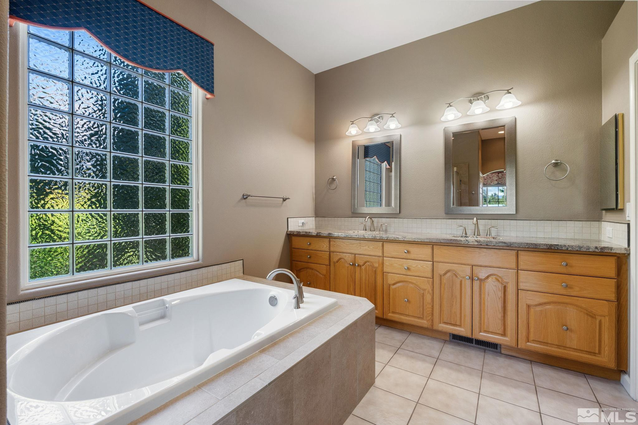 1745 Hunter Creek Road Reno, NV 89519 - Photo 29 of 40 a bathroom with a tub sink and mirror