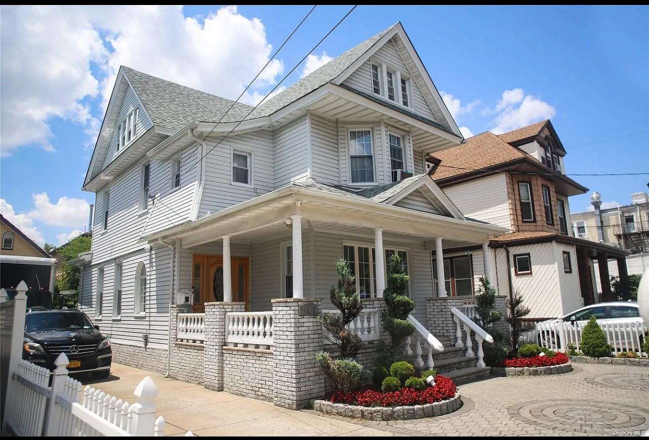 View of front facade featuring covered porch, roof with shingles, and cooling unit