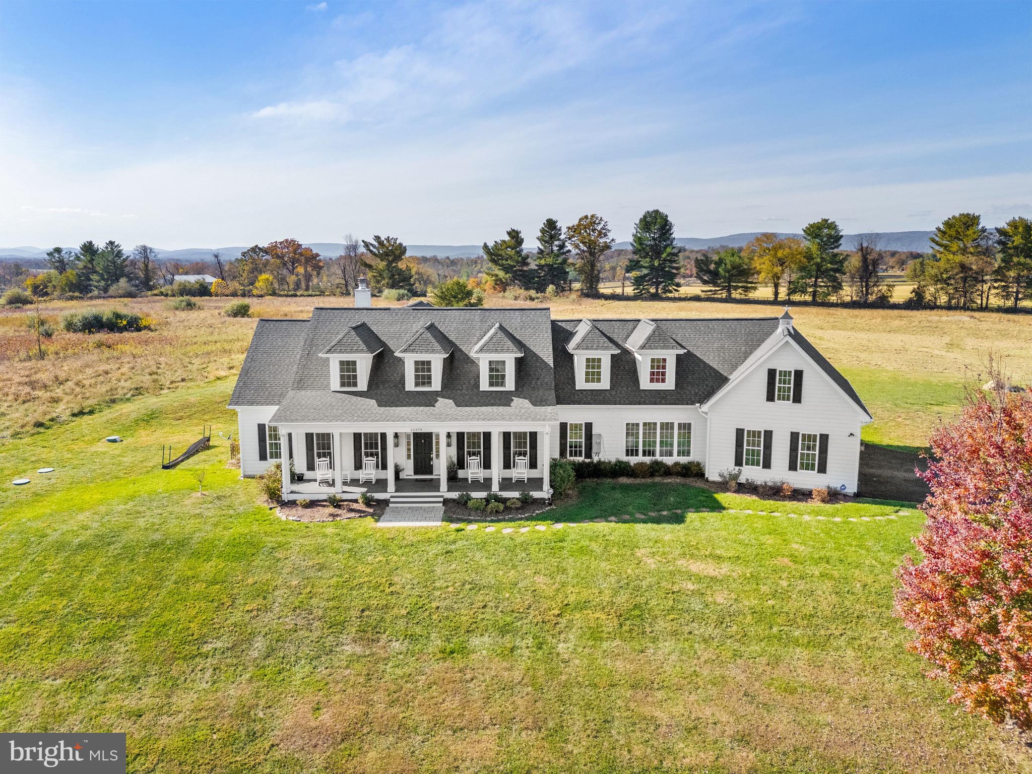 a view of a house with a big yard and large trees