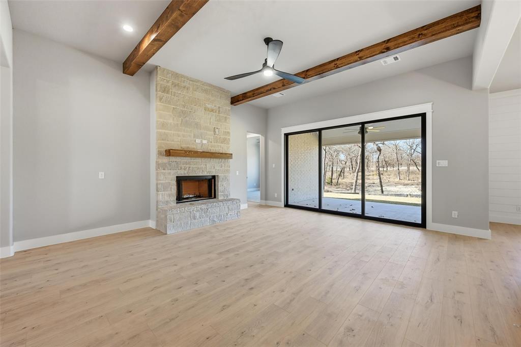 1053 Llano Way Poolville, TX 76487 - Photo 10 of 40 a view of an empty room with a fireplace and a window
