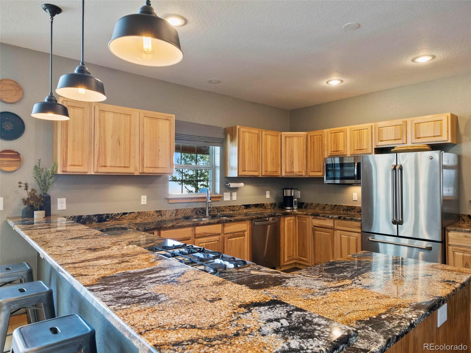 8335 Doubleheader Ranch Road Morrison, CO 80465 - Photo 11 of 40 a kitchen with stainless steel appliances granite countertop a sink stove and refrigerator