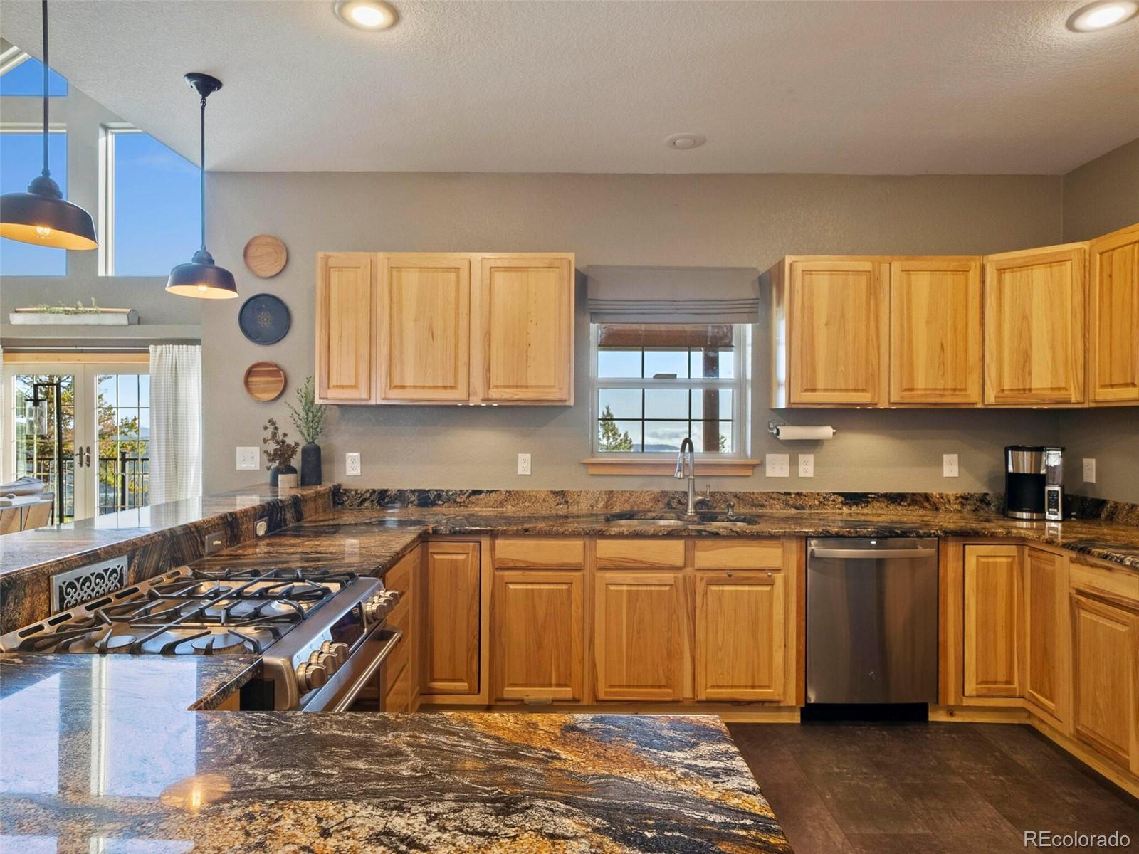 8335 Doubleheader Ranch Road Morrison, CO 80465 - Photo 13 of 40 a kitchen with stainless steel appliances granite countertop a stove a sink and a microwave