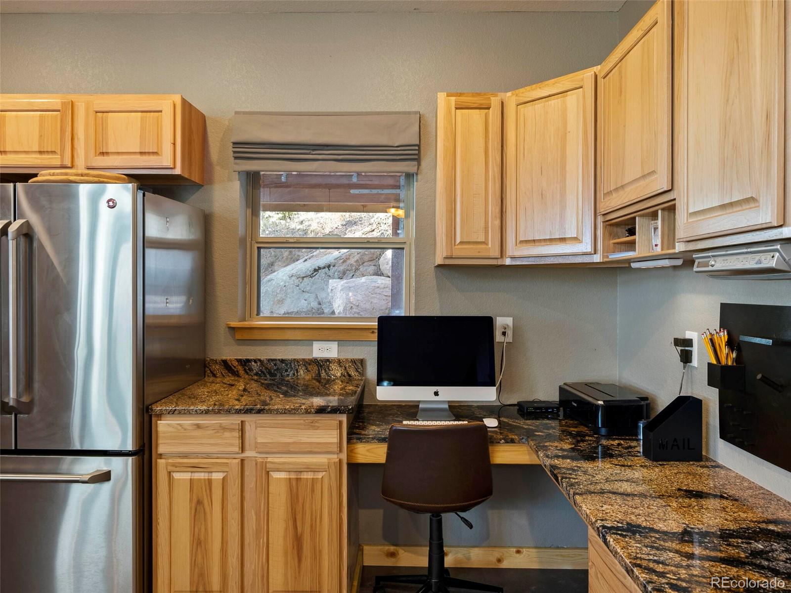 8335 Doubleheader Ranch Road Morrison, CO 80465 - Photo 14 of 40 a kitchen with stainless steel appliances granite countertop a stove refrigerator and a microwave