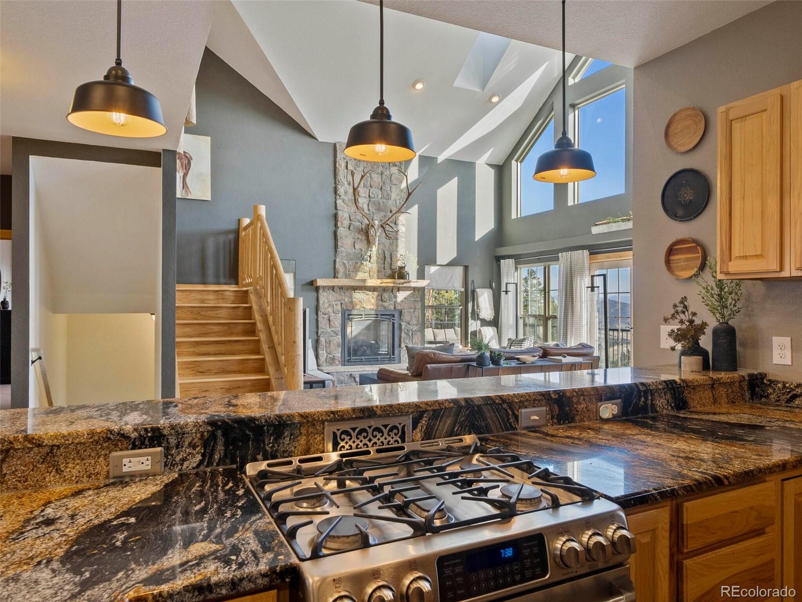 8335 Doubleheader Ranch Road Morrison, CO 80465 - Photo 15 of 40 a kitchen with stainless steel appliances granite countertop a stove a sink and a microwave