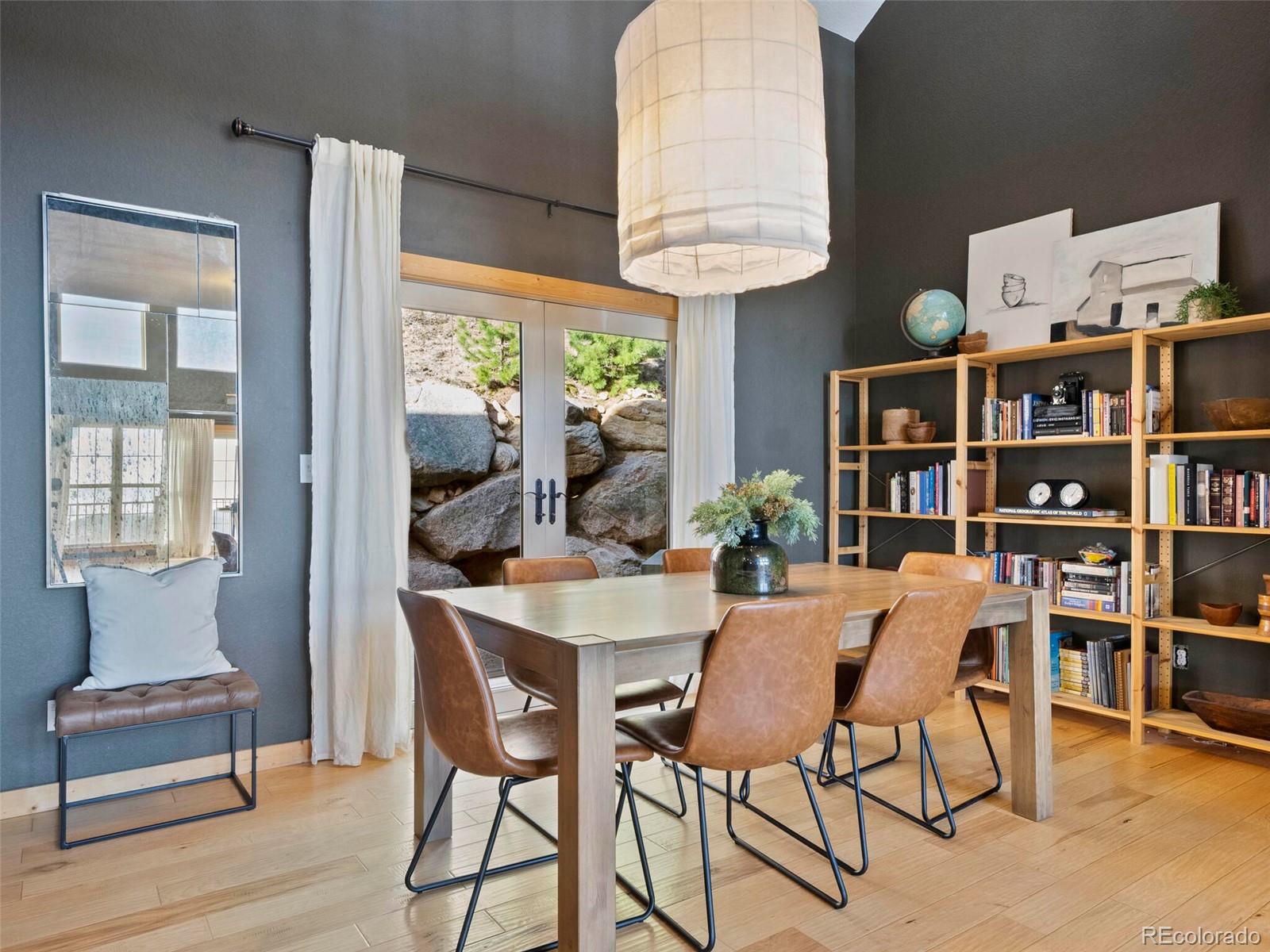 8335 Doubleheader Ranch Road Morrison, CO 80465 - Photo 16 of 40 a view of a dining room with furniture window and wooden floor
