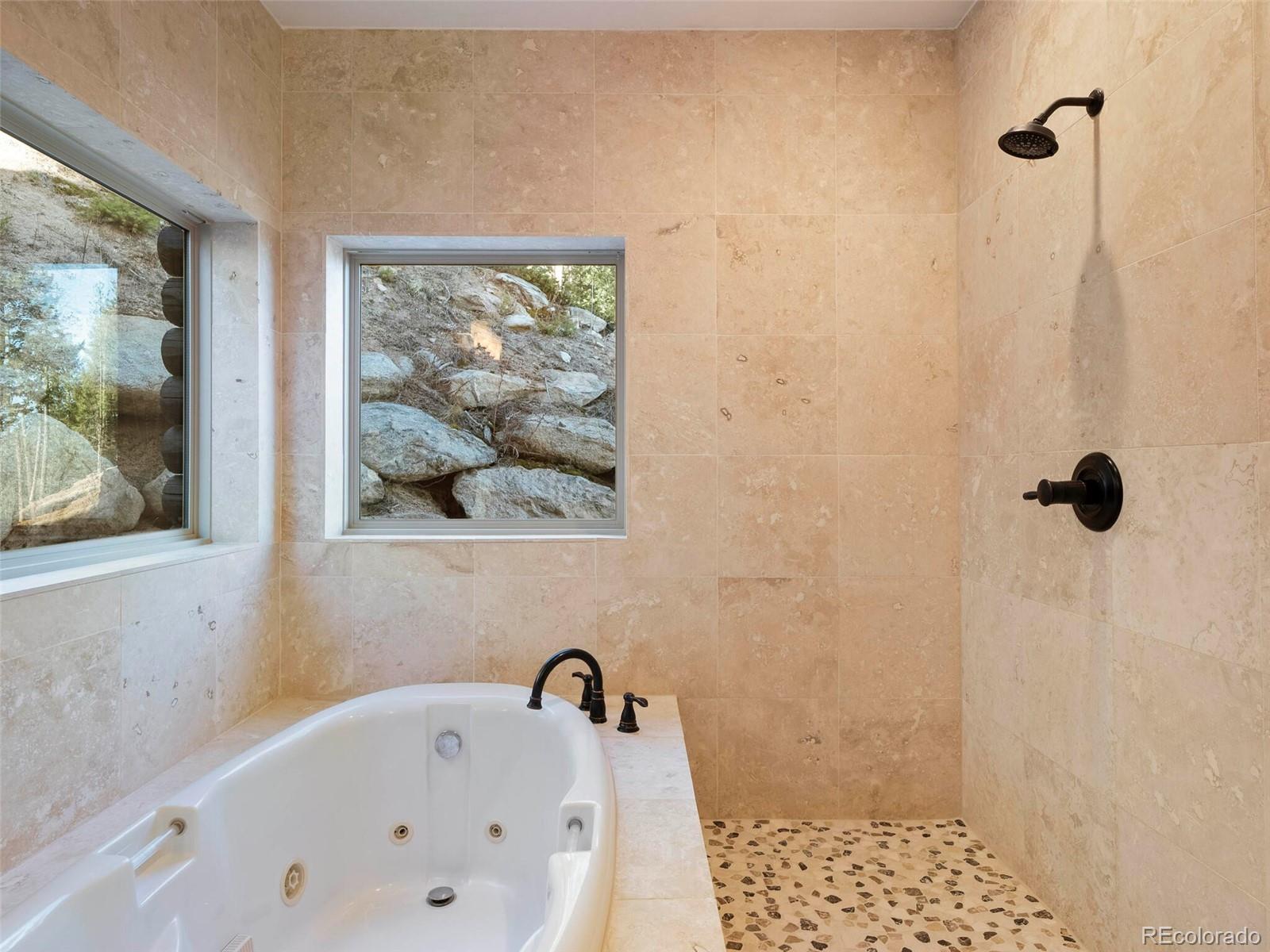 8335 Doubleheader Ranch Road Morrison, CO 80465 - Photo 22 of 40 a bathroom with a bathtub and shower