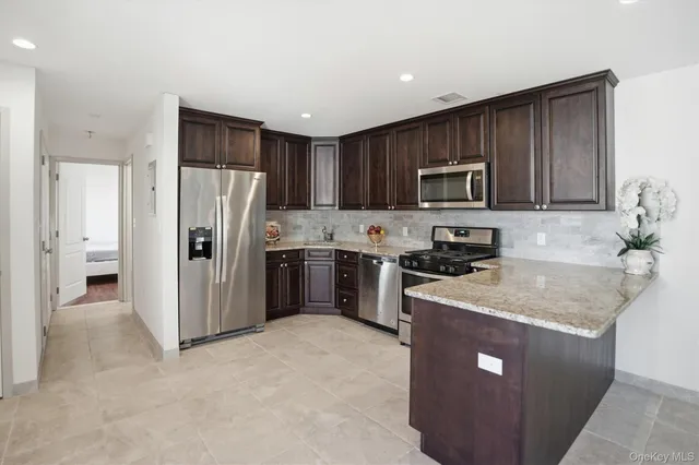 a kitchen with stainless steel appliances granite countertop a refrigerator stove microwave and sink