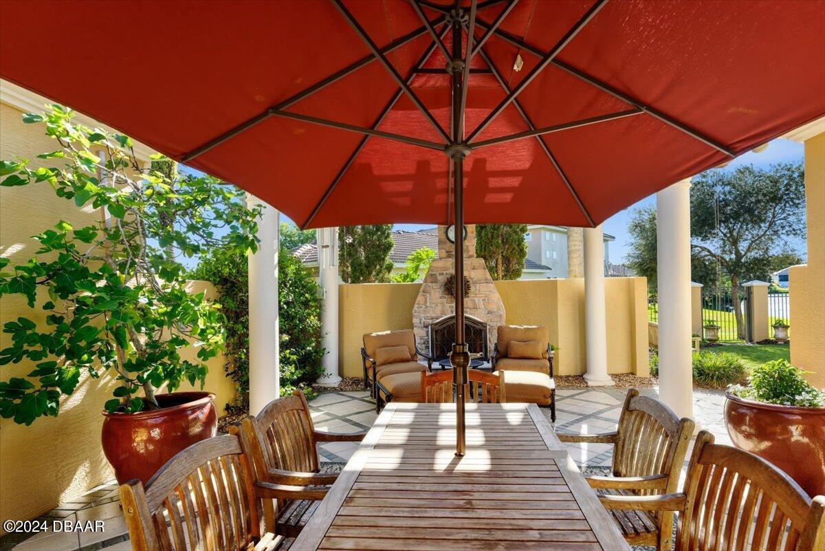 6 Old Canyon Lane Ormond Beach, FL 32174 - Photo 5 of 71 a view of a patio with table and chairs under an umbrella