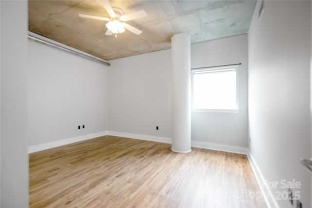 an empty room with a window and a ceiling fan
