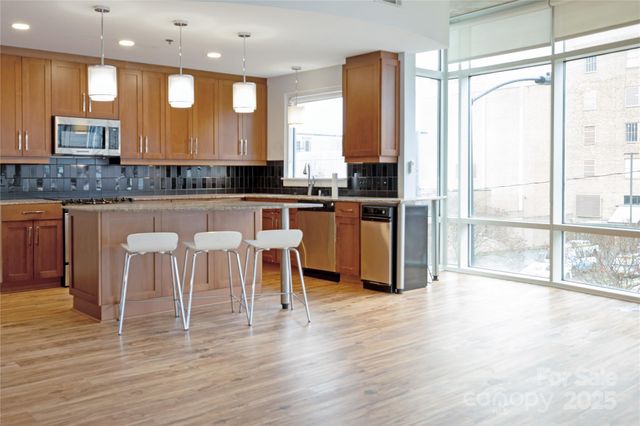 a kitchen with stainless steel appliances granite countertop a stove top oven a sink and a granite counter top