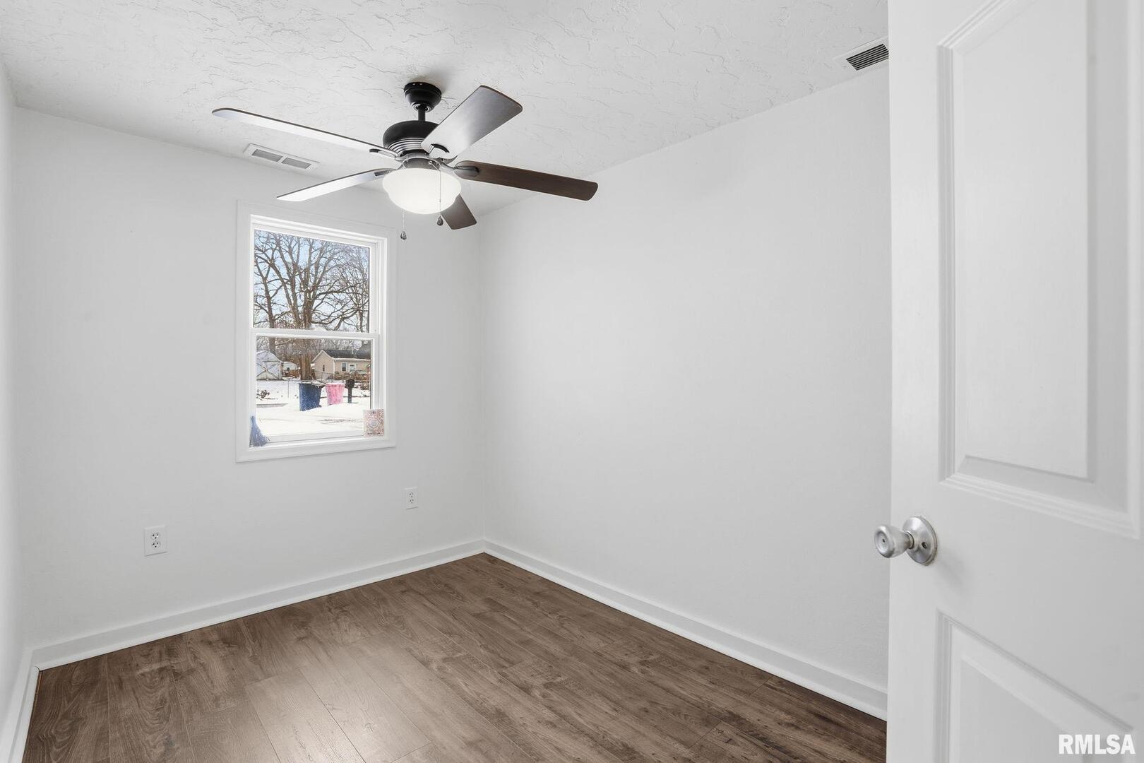 1015 7th Street Colona, IL 61241 - Photo 15 of 19 a view of empty room with wooden floor and fan