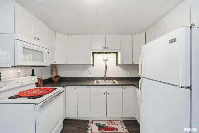 a kitchen with a sink a refrigerator and cabinets