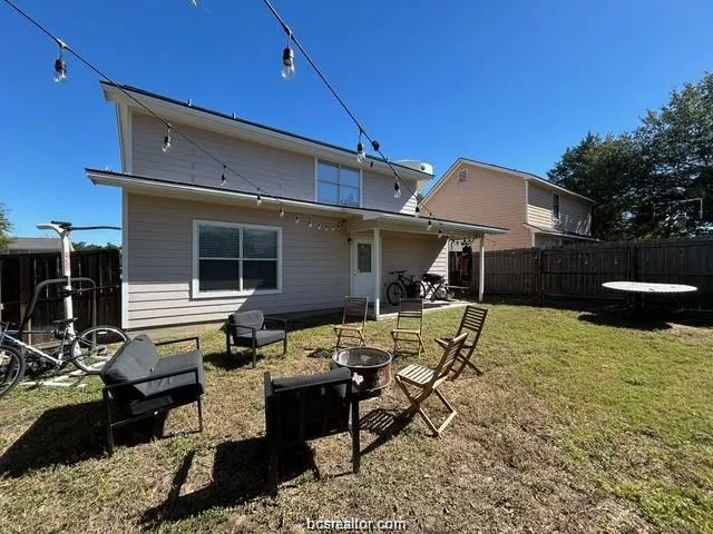 a view of a patio with table and chairs with wooden fence