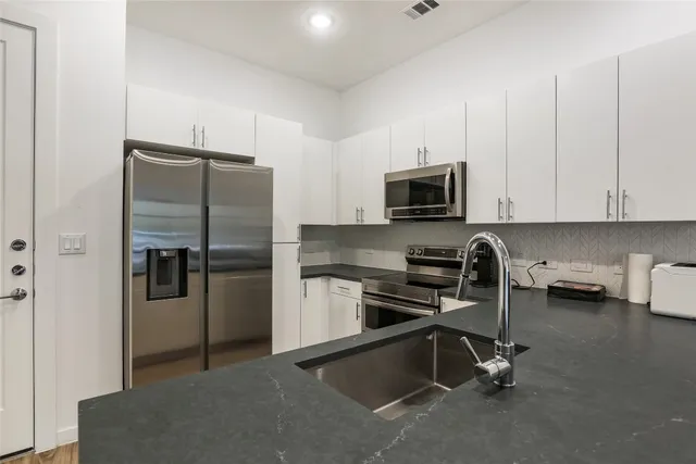 a kitchen with a stove a sink and a refrigerator