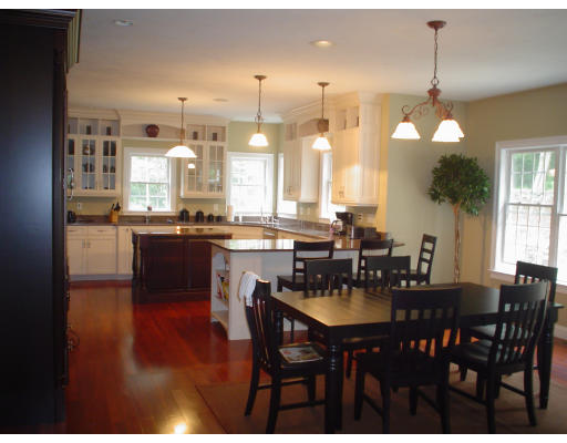 71 Stone School Road Sutton, MA 01590 - Photo 8 of 30 a kitchen with a dining table chairs and white cabinets