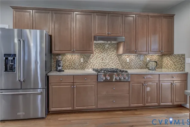 a kitchen with stainless steel appliances granite countertop a refrigerator and a sink