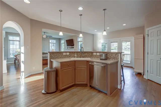 a kitchen with kitchen island granite countertop wooden floors and wide window