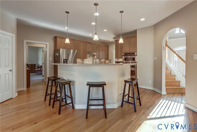 a kitchen with stainless steel appliances kitchen island wooden floors and view living room