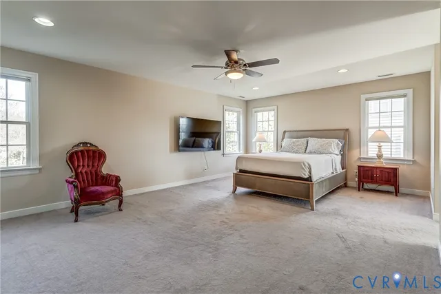 a spacious bedroom with a bed and a chair