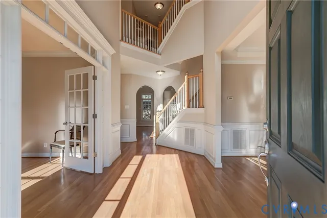a view of a hallway with wooden floor and furniture