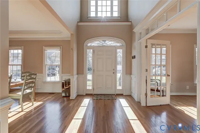 a view of a hallway with wooden floor and windows