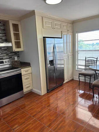 a kitchen with granite countertop a refrigerator stove and sink