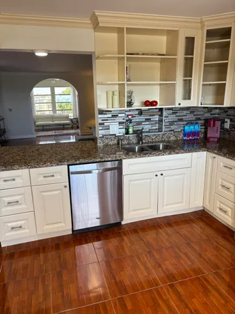 a kitchen with granite countertop a sink and cabinets