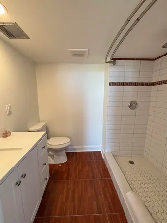 a bathroom with a granite countertop bathtub shower sink and toilet