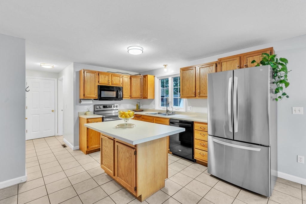 44 Border Street Springfield, MA 01104 - Photo 12 of 37 a kitchen with a refrigerator a microwave oven and a sink with wooden floor